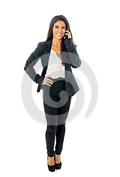 Full length portrait of Attractive latin corporate latin woman looking confident making a call on her mobile phone in Creative