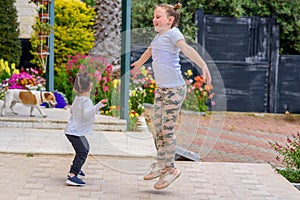 Full length portrait of attractive, playful, cheerful, happy comic couple children jumping over nature background.