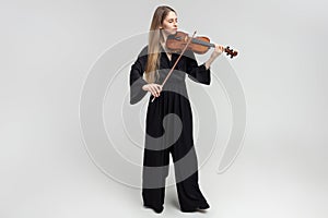 Full length portrait of attractive woman musician playing violin