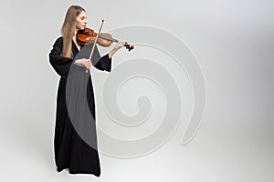 Full length portrait of attractive woman musician playing violin