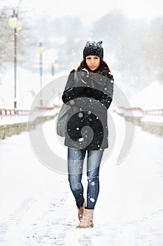 Full length portrait of attractive young woman in winter park
