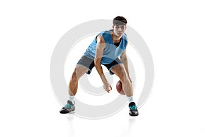 Full length portrait of basketball player practicing isolated on white studio background. Tall muscular athlete