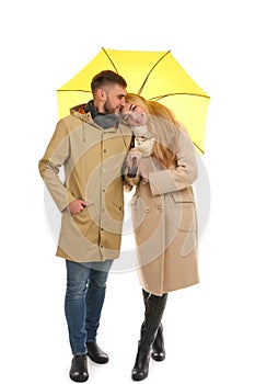 Full length portrait of beautiful couple with umbrella