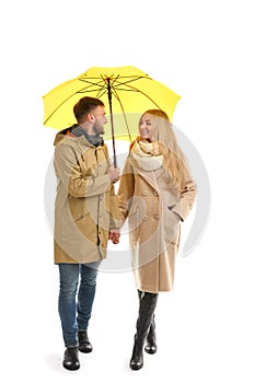 Full length portrait of beautiful couple with umbrella