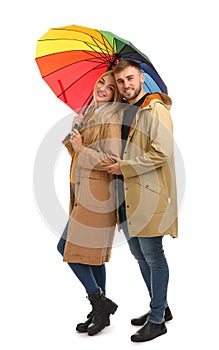 Full length portrait of beautiful couple with umbrella