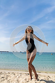 Full length portrait of beautiful happy woman standing in sea, swimming. Young happy cheerful woman in bikini smiling, enjoying