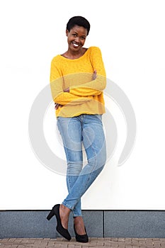 Full length beautiful young african american woman smiling against white wall