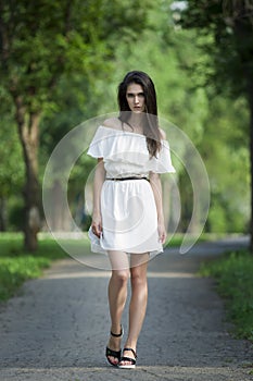 Full length portrait of a beautiful young caucasian woman in white dress with open shoulders, clean skin, long hair and casual