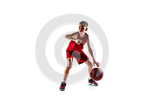 Full-length portrait of boy, basketball player in red uniform training isolated over white background. Bounce pass