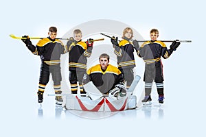 Full-length portrait of boys, children, professional hockeys player  over white background. Competition