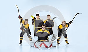 Full-length portrait of boys, children, professional hockeys player  over white background. Team game