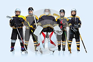 Full-length portrait of boys, children, professional hockeys player  over white background. Team spirit