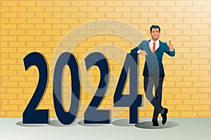 Full length portrait of a businessman standing next to 2024 words and showing thumbs up isolated on yellow brick wall background