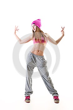 Full-length portrait of carefree girl in gray pants, pink top and hat jumping and dancing. Teen girl hip-hop dancer, over white