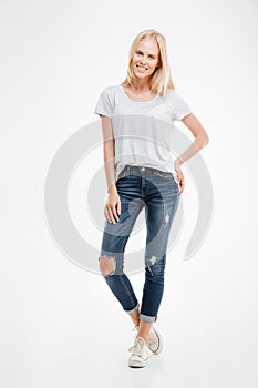 Full length portrait of a casual happy blonde woman standing