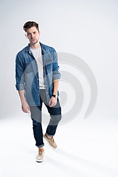 Full length portrait of a casual man standing over white background.