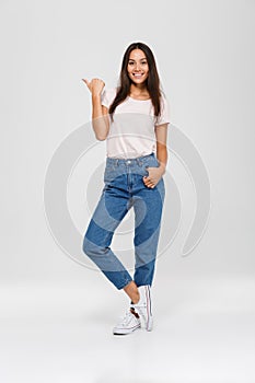 Full length portrait of a casual pretty asian woman standing