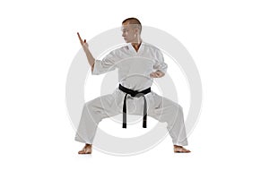 Full-length portrait of caucasian sportsman standing in a fight pose isolated over white background. Karate, judo