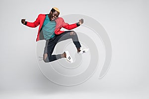 Full length portrait of a cheerful afro american man jumping isolated on a white background