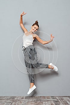Full length portrait of a cheerful cute woman jumping