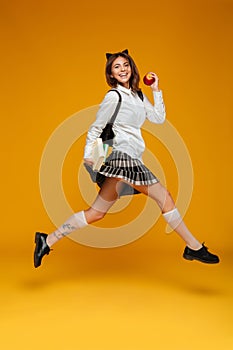 Full length portrait of a cheerful schoolgirl in uniform
