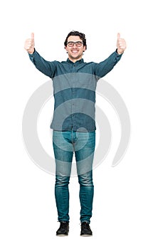 Full length portrait of cheerful and successful businessman, shows thumbs up gesture, looking to camera isolated on white