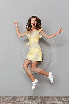 Full length portrait of a cheerful young girl in dress