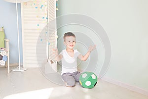 Full length portrait of a child with a soccer ball in home