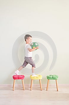 Full length portrait of a child with a soccer ball isolated in home