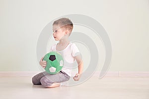 Full length portrait of a child with a soccer ball isolated in home