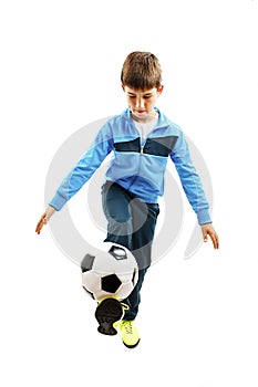 Full length portrait of a child in sportswear jogging with a soccer ball
