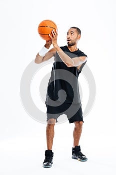 Full length portrait of a concentrated african man playing basketball