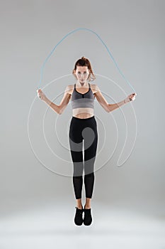 Full length portrait of a confident healthy fitness woman jumping