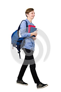 Full length portrait of confident student boy going to school holding two books and carrying his backpack. Cheerful teenager