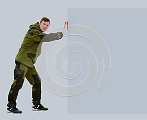 Full length portrait of confident young male cleaner holding mop standing over white background.