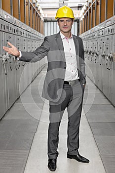 Full length portrait of confident young male inspector gesturing in control room