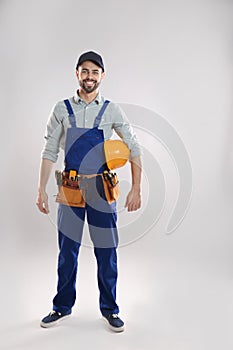 Full length portrait of construction worker with hard hat and tool belt
