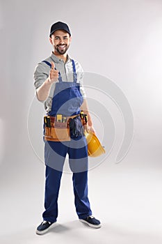 Full length portrait of construction worker with hard hat and tool belt