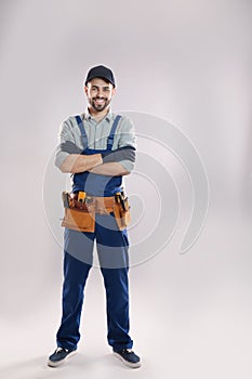 Full length portrait of construction worker with tool belt