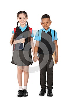 Full length portrait of cute children in school uniform with books on white