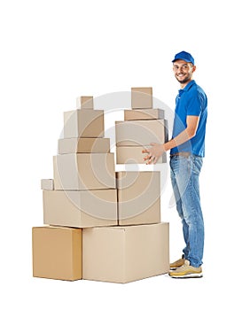 Full length portrait of delivery man holding stack of boxes