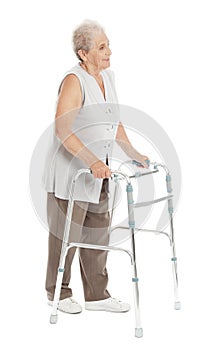 Full length portrait of elderly woman using walking frame isolated