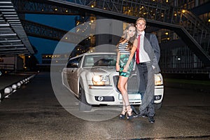 Full length portrait of elegant young couple standing in front o