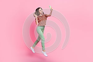 Full length portrait of excited active person jump rush hold telephone take selfie arm waving hi isolated on pink color