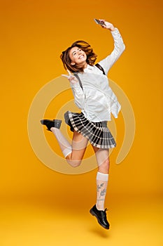 Full length portrait of an excited teenage schoolgirl in uniform