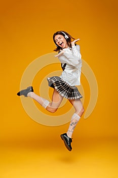 Full length portrait of an excited teenage schoolgirl in uniform