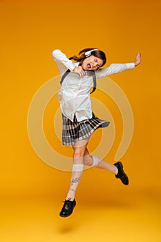 Full length portrait of an excited teenage schoolgirl in uniform