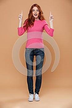 Full length portrait of an excited young redhead girl