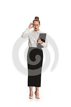 Full length portrait of female teacher with a headache holding a folder isolated against white background