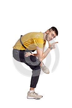Full-length portrait of a funny guy dancing in studio isolated on white background.